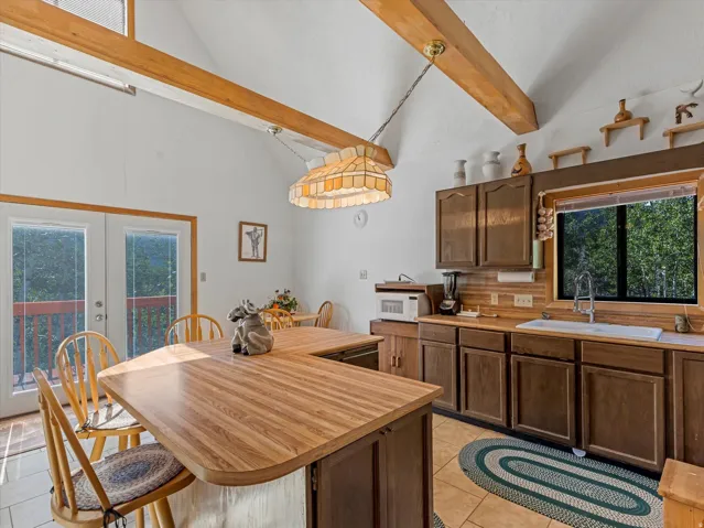 Kitchen featuring wood-finish countertops, wood cabinetry, and a double basin sink with an arched faucet