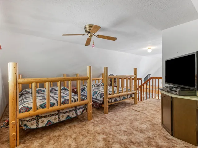 Carpeted loft space featuring sloped ceilings, a ceiling fan, and recessed lighting