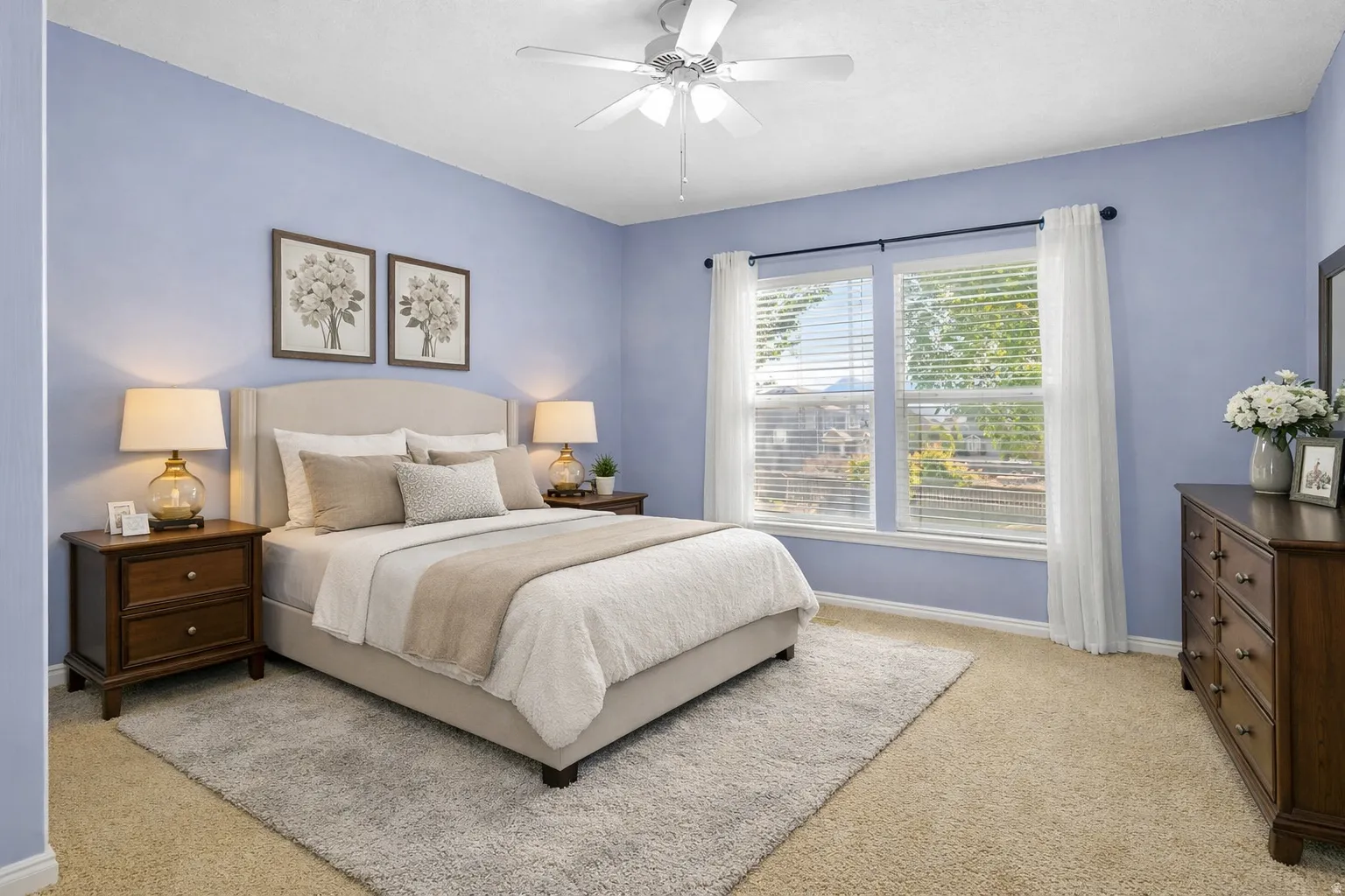 Bedroom featuring a ceiling fan, dual windows with blinds, light blue wall paint, and carpet flooring