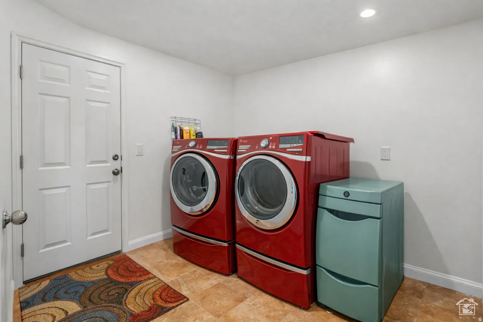 Utility room featuring a paneled door, tile flooring, and recessed lighting