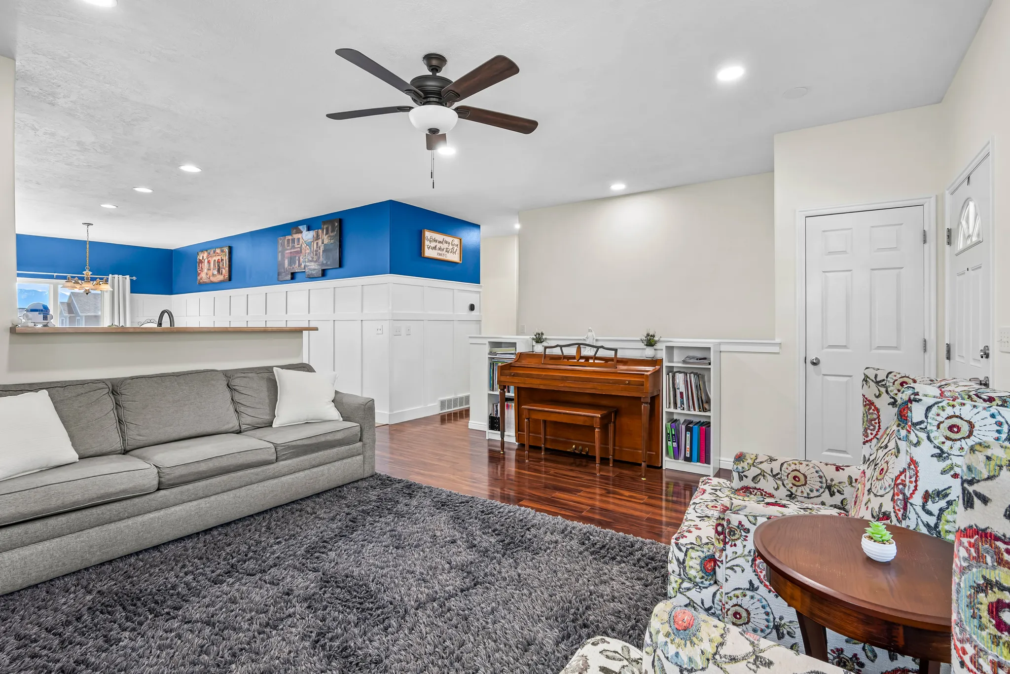 Open-concept living space featuring wood-finish flooring, recessed lighting, and a ceiling fan