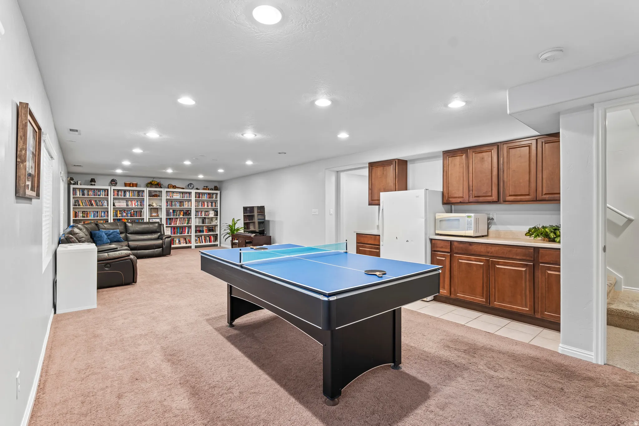 Spacious recreation room featuring carpeted flooring and recessed lighting