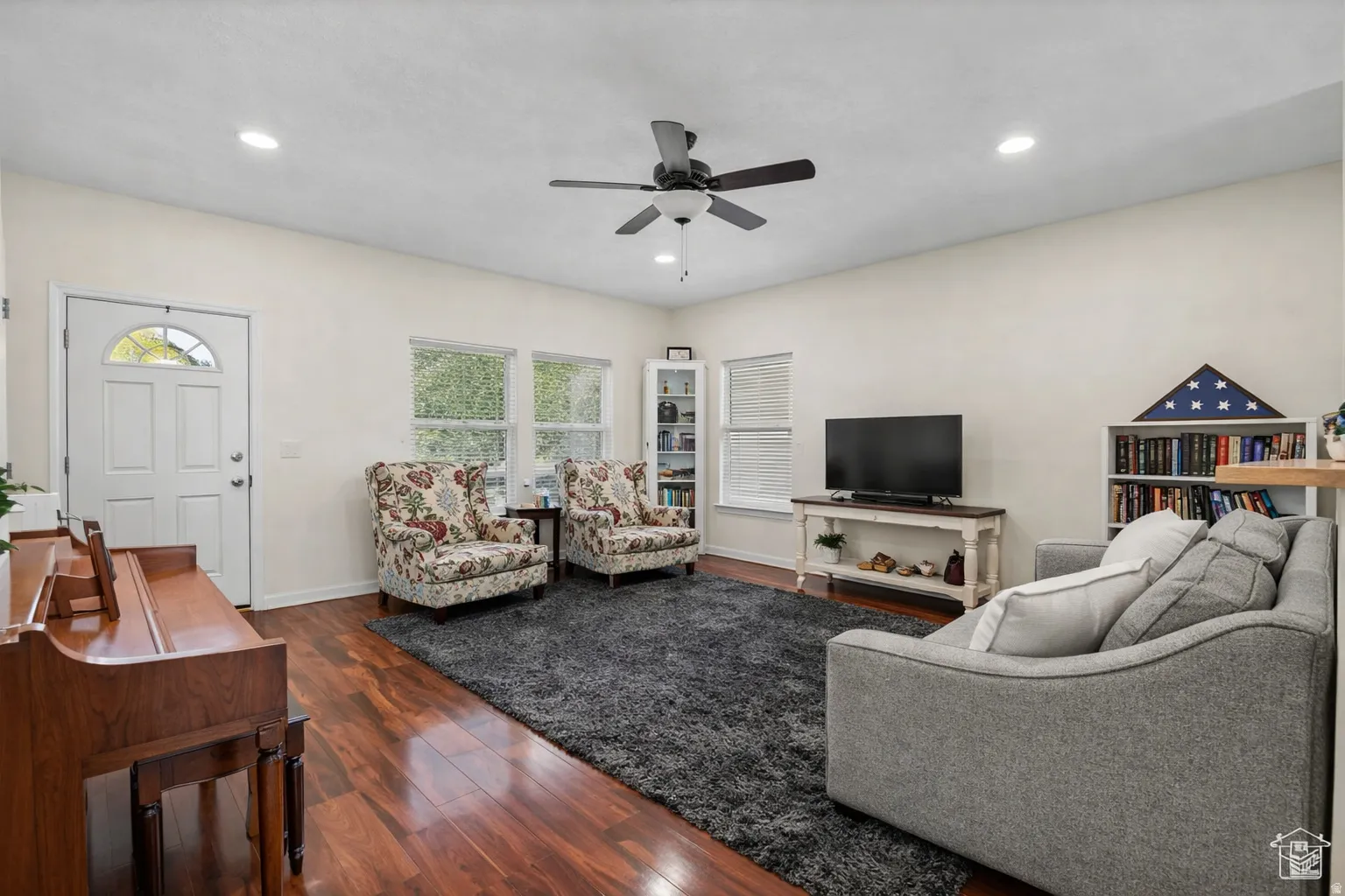 Spacious living area featuring wood-finish flooring, recessed lighting, and a ceiling fan