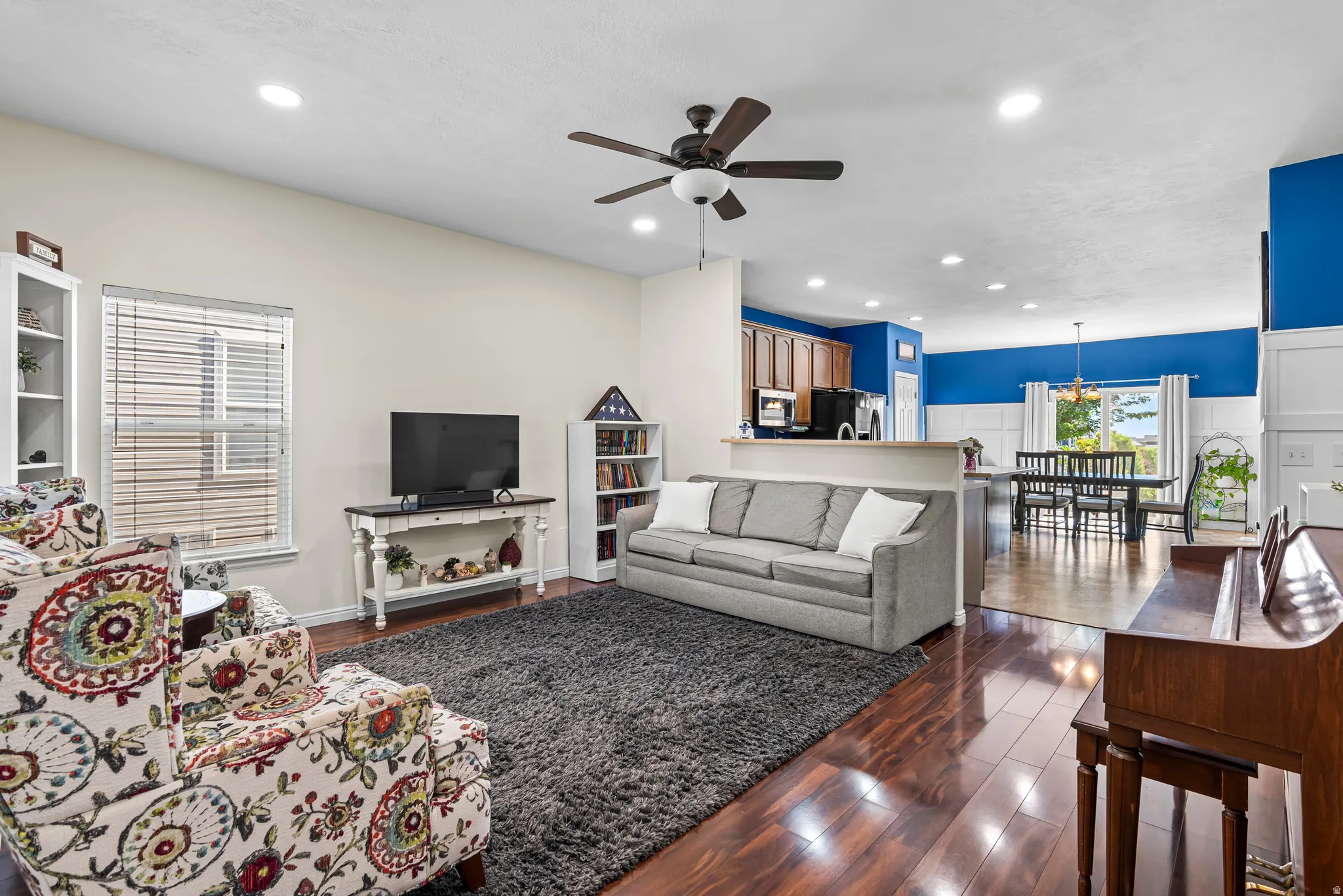 Open-concept living area featuring wood-finish flooring, recessed lighting, and a ceiling fan