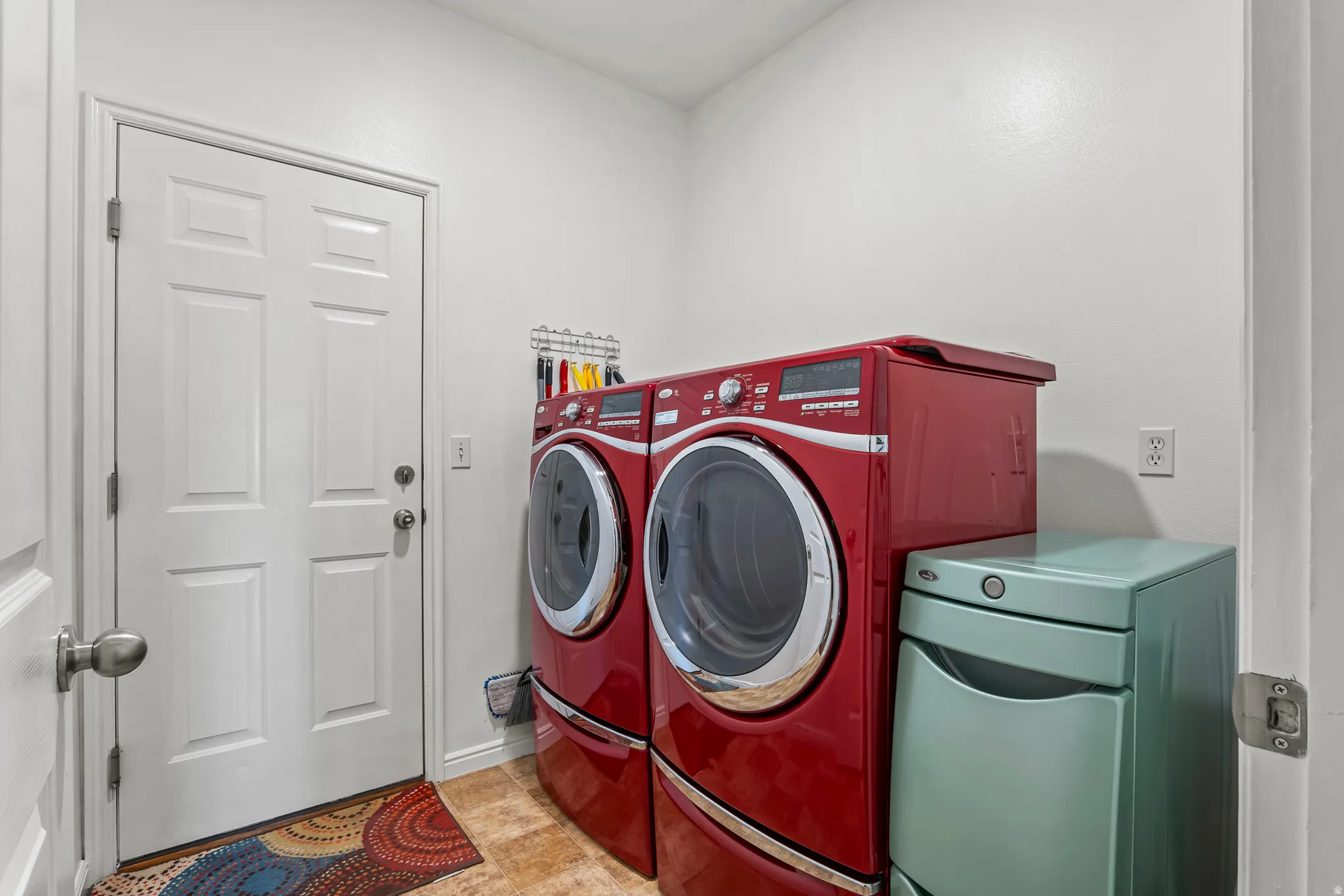 Bright utility space featuring white paneled door, light-toned walls, and tile flooring