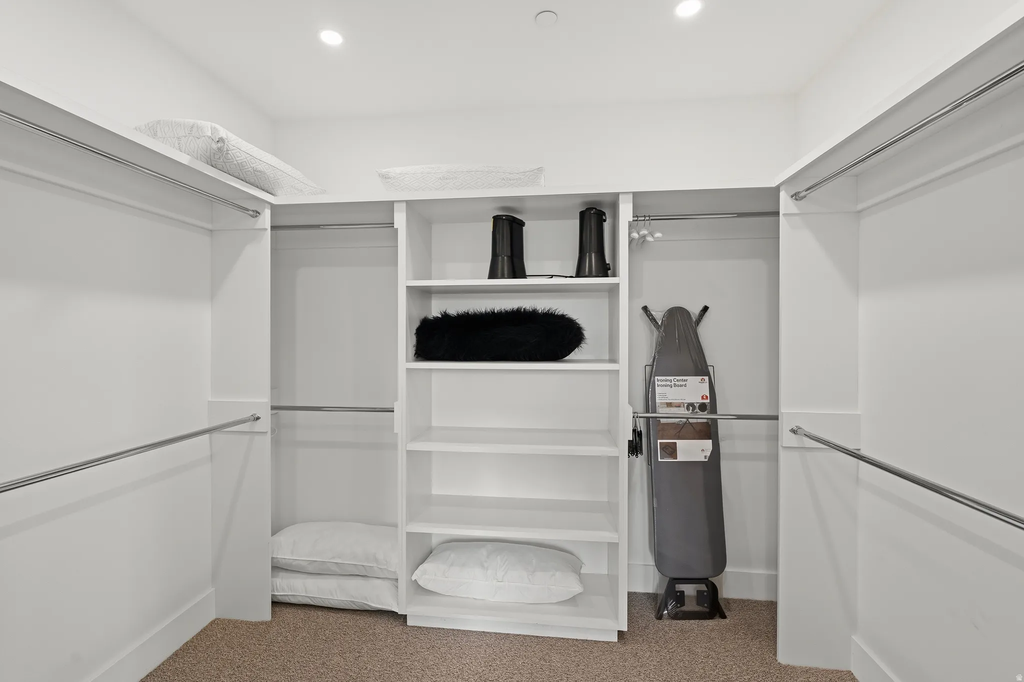 Walk-in closet featuring built-in shelving, multiple hanging rods, recessed lighting, and carpeting