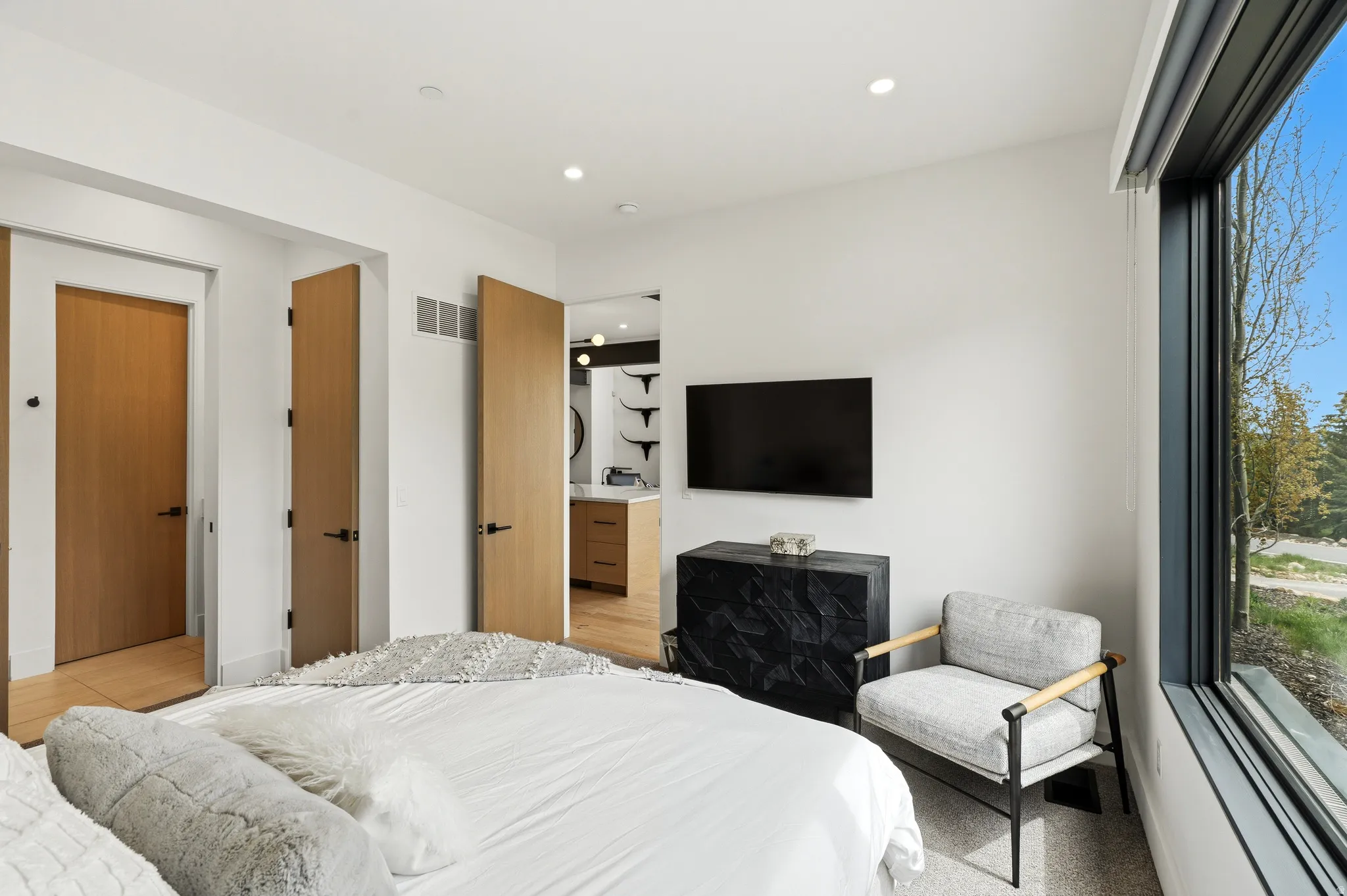 Bedroom featuring a large picture window, recessed lighting, and light wood-finish doors