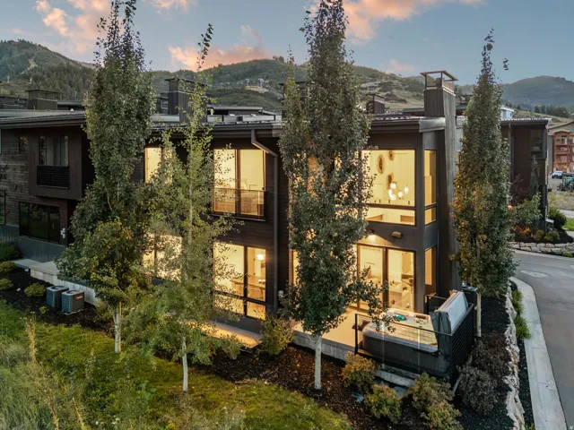 Contemporary architecture featuring large multi-pane windows, a private patio, and an integrated hot tub