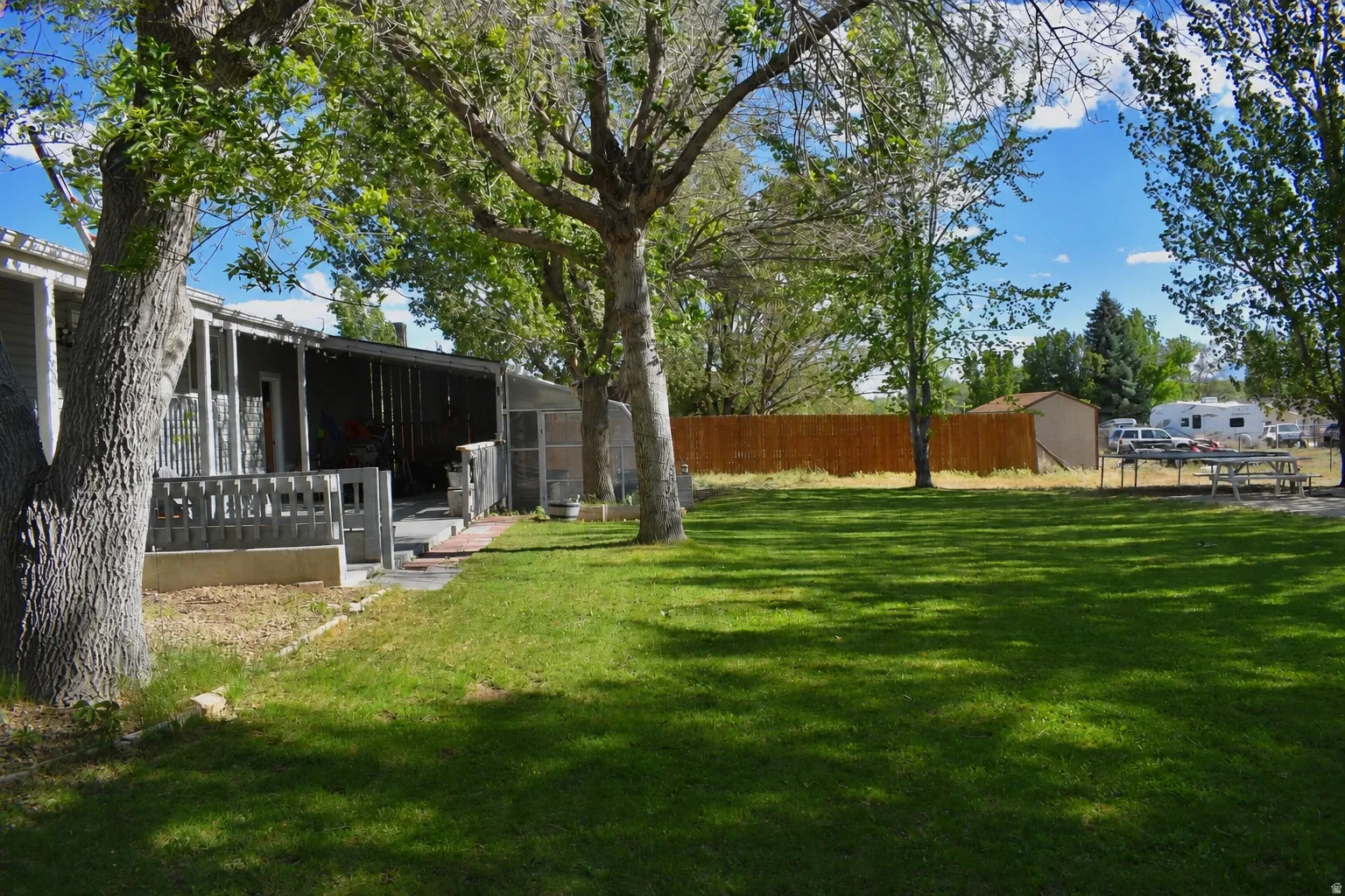 Expansive lawn area featuring mature trees providing natural shade