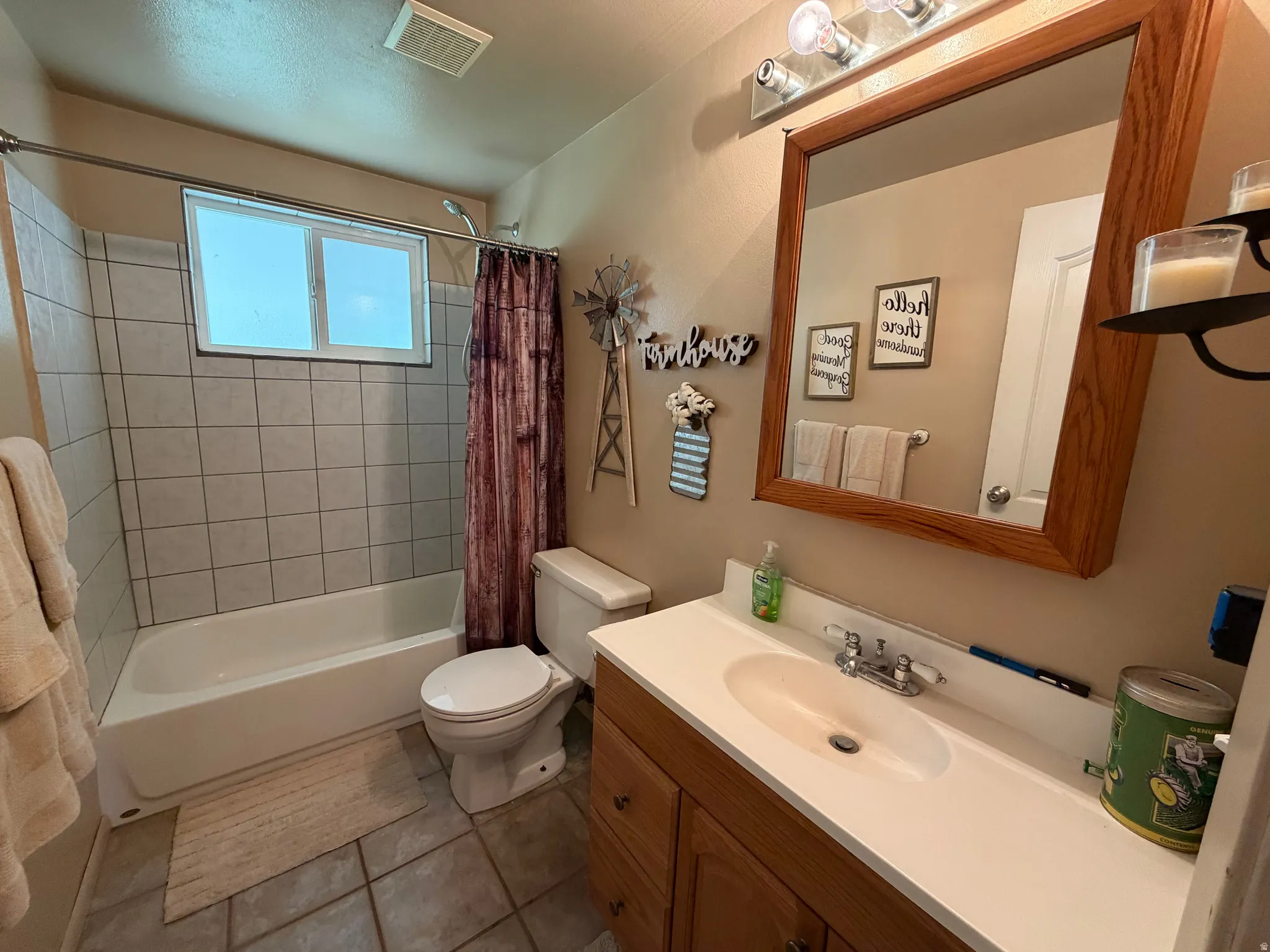 Bathroom featuring a white bathtub, ceramic tile surround, and a window for natural light