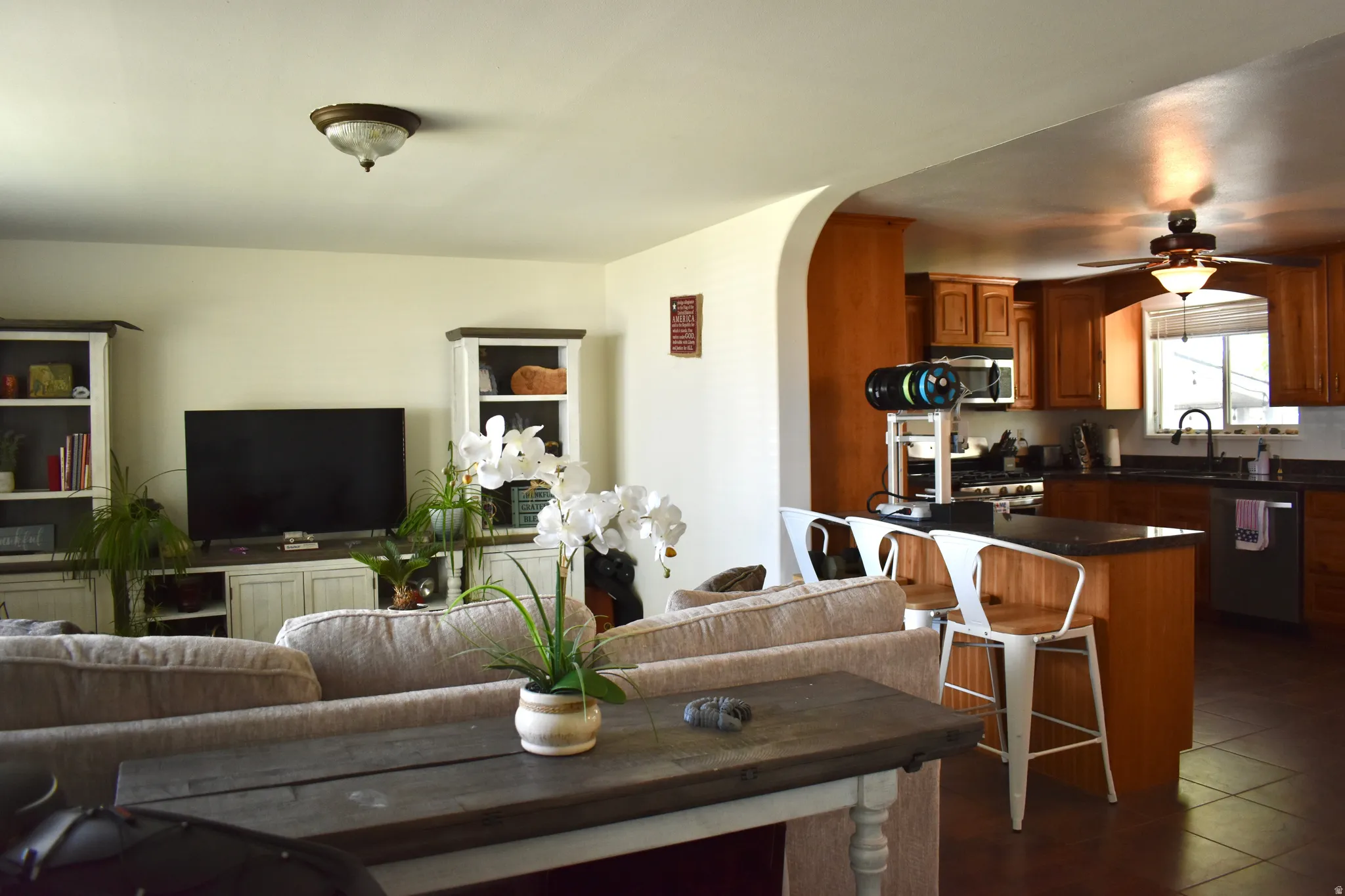 Open concept living space featuring a partial wall with an arched doorway