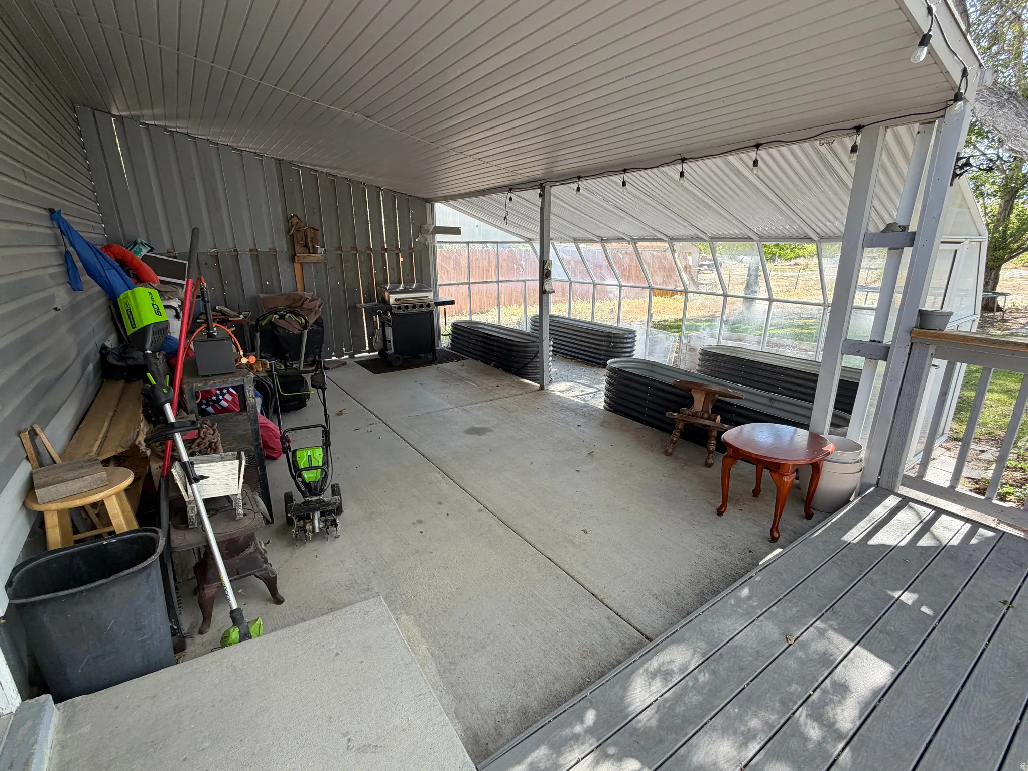 Expansive covered patio featuring a corrugated metal roof and concrete flooring