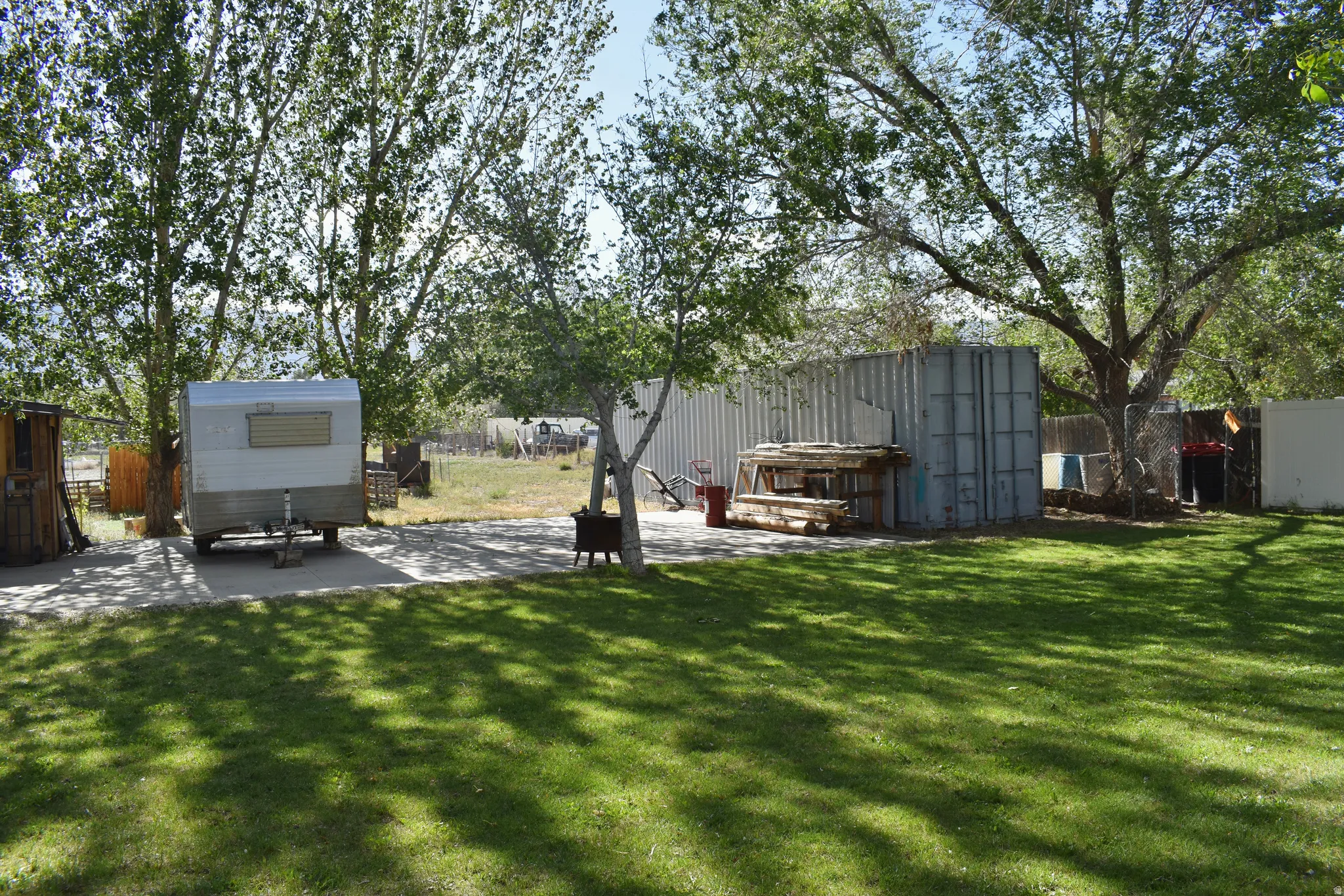 Expansive green lawn area featuring mature trees providing natural shade