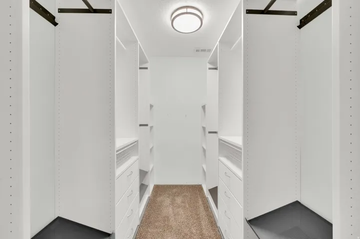 Custom closet system featuring white shelving and integrated drawer units