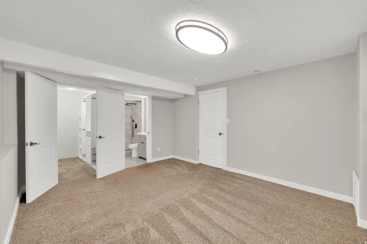 Spacious room featuring neutral carpet flooring and light gray walls