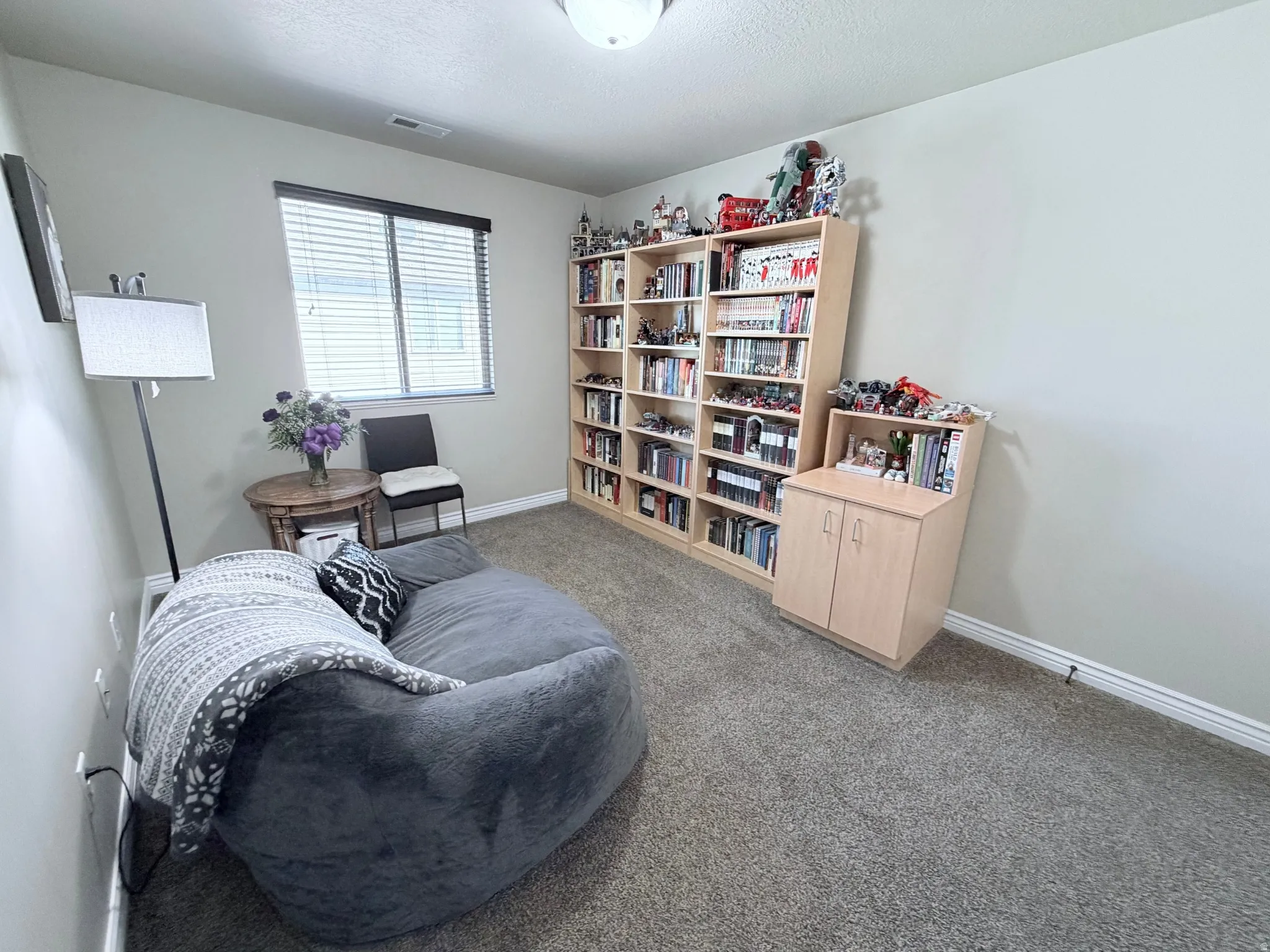 Bedroom #2 with light-colored walls, light carpet and a window with blinds