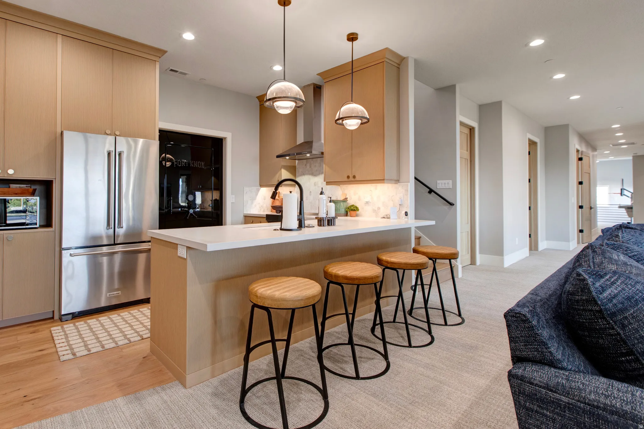 Kitchen featuring a white countertop island, stainless steel appliances, wood-finish flooring, and recessed lighting