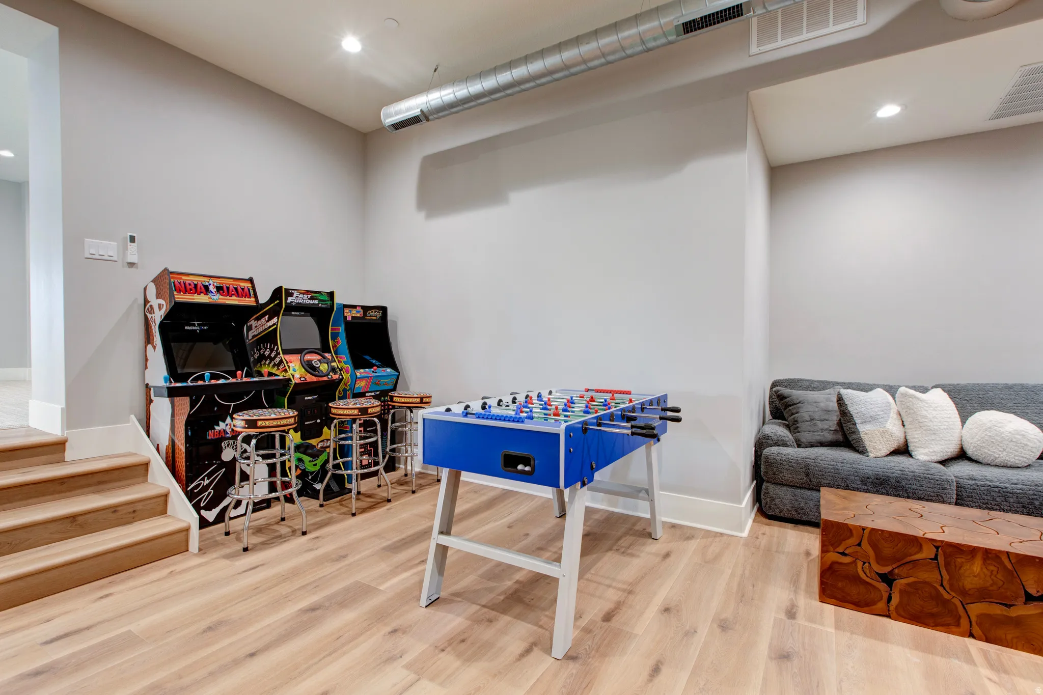 Lower level recreation room featuring wood-finish flooring, recessed lighting, and a visible HVAC duct system