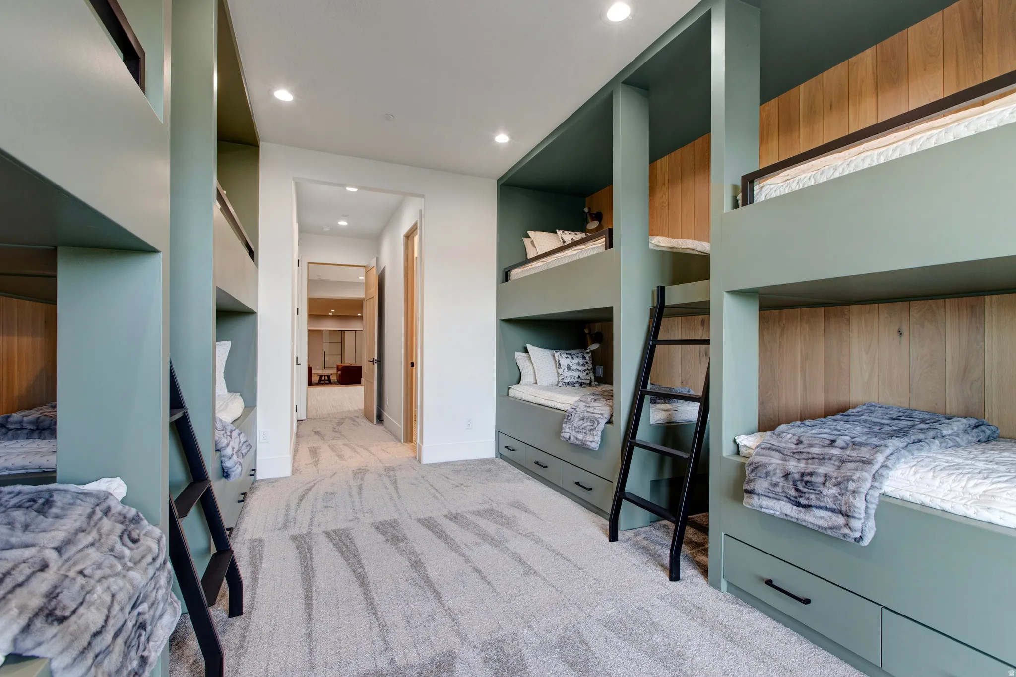 Built-in bunk beds featuring a sage green finish and wood-panel accents