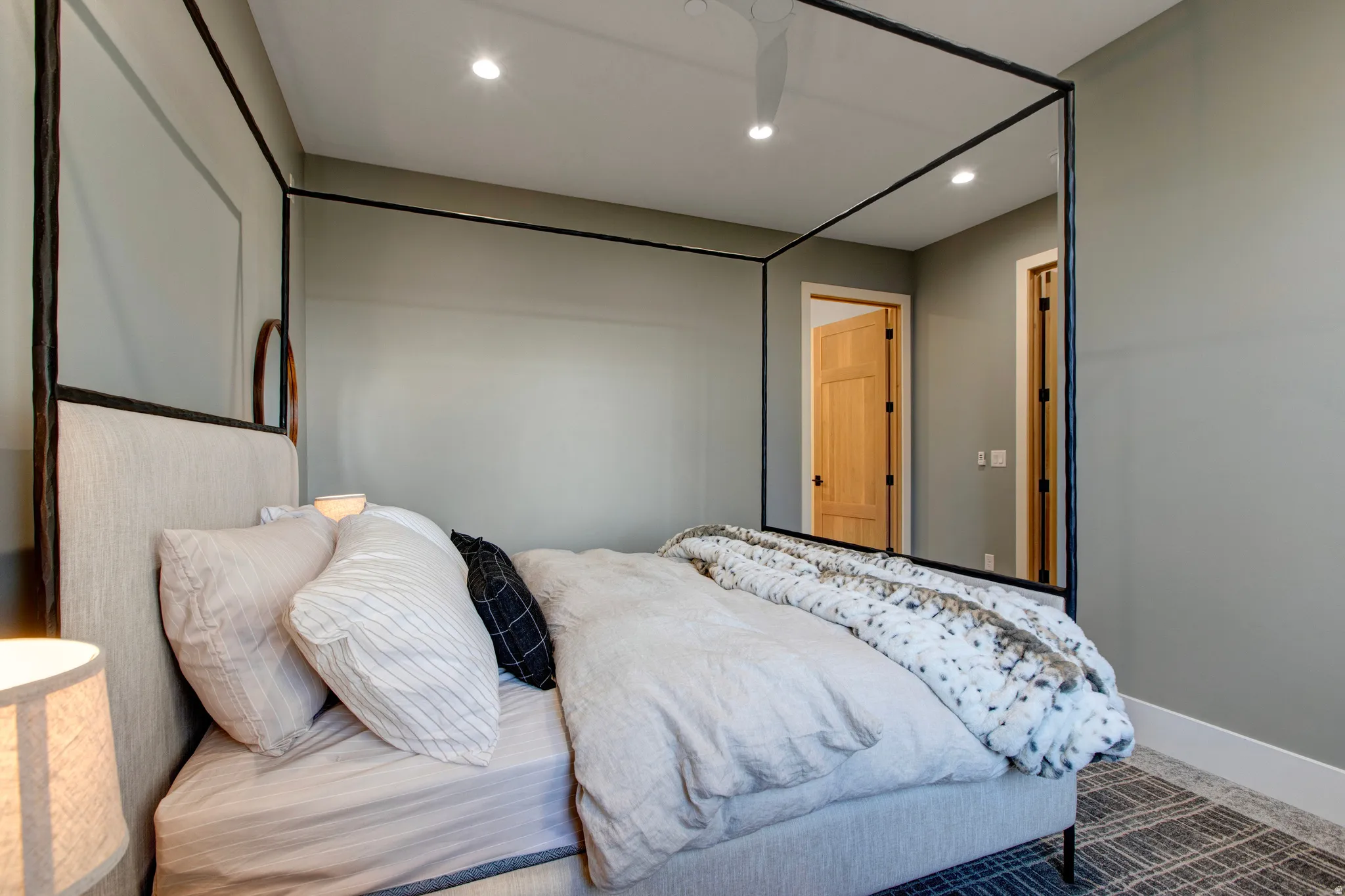 Interior room featuring light gray walls, recessed ceiling lighting, and wood-finish doors with black hardware