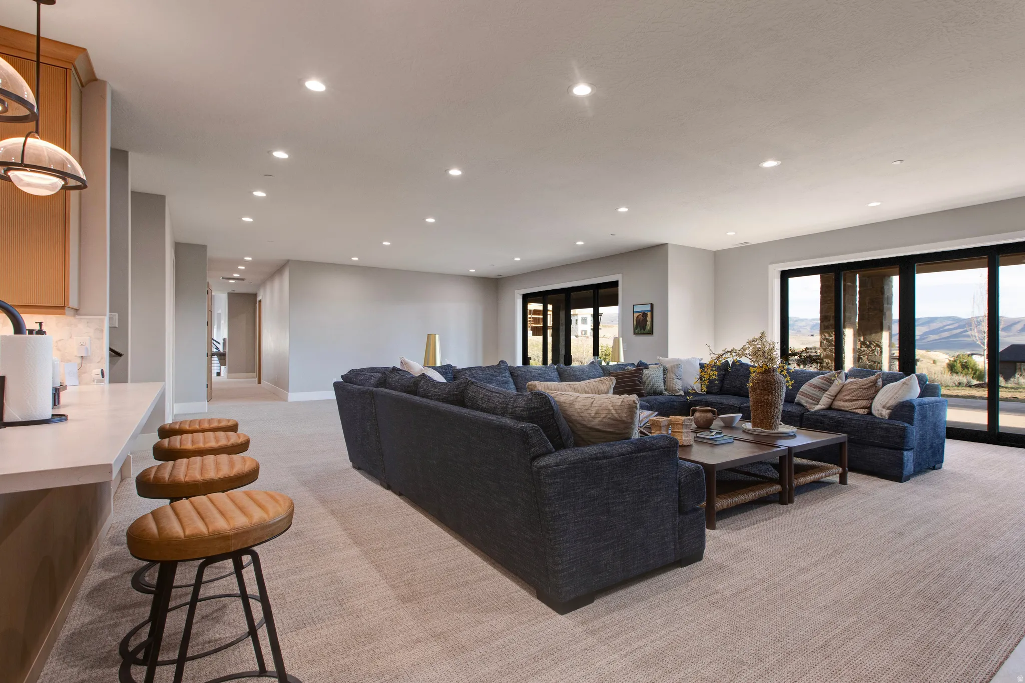 Open-concept living area featuring light-toned carpeting and recessed lighting