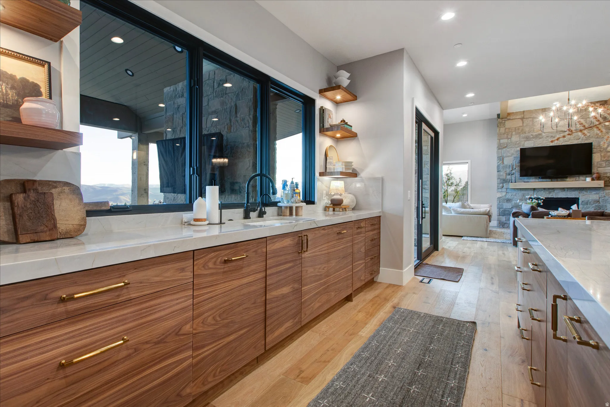 Custom cabinetry with brass hardware, light-toned countertops, and an undermount sink