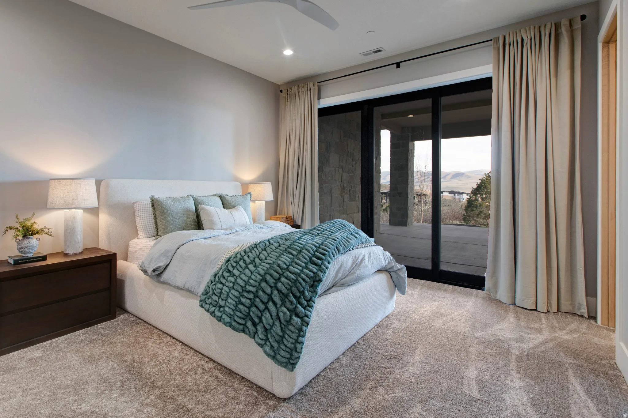Carpeted room featuring a modern ceiling fan, recessed lighting, and a full-length sliding glass door opening to a private outdoor area