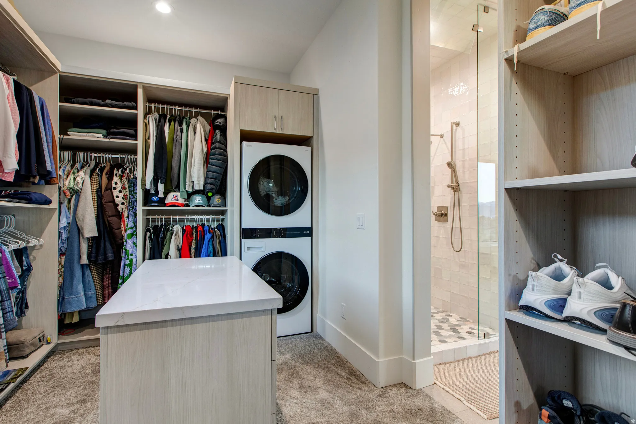 Custom closet organization system featuring a central island with a white countertop