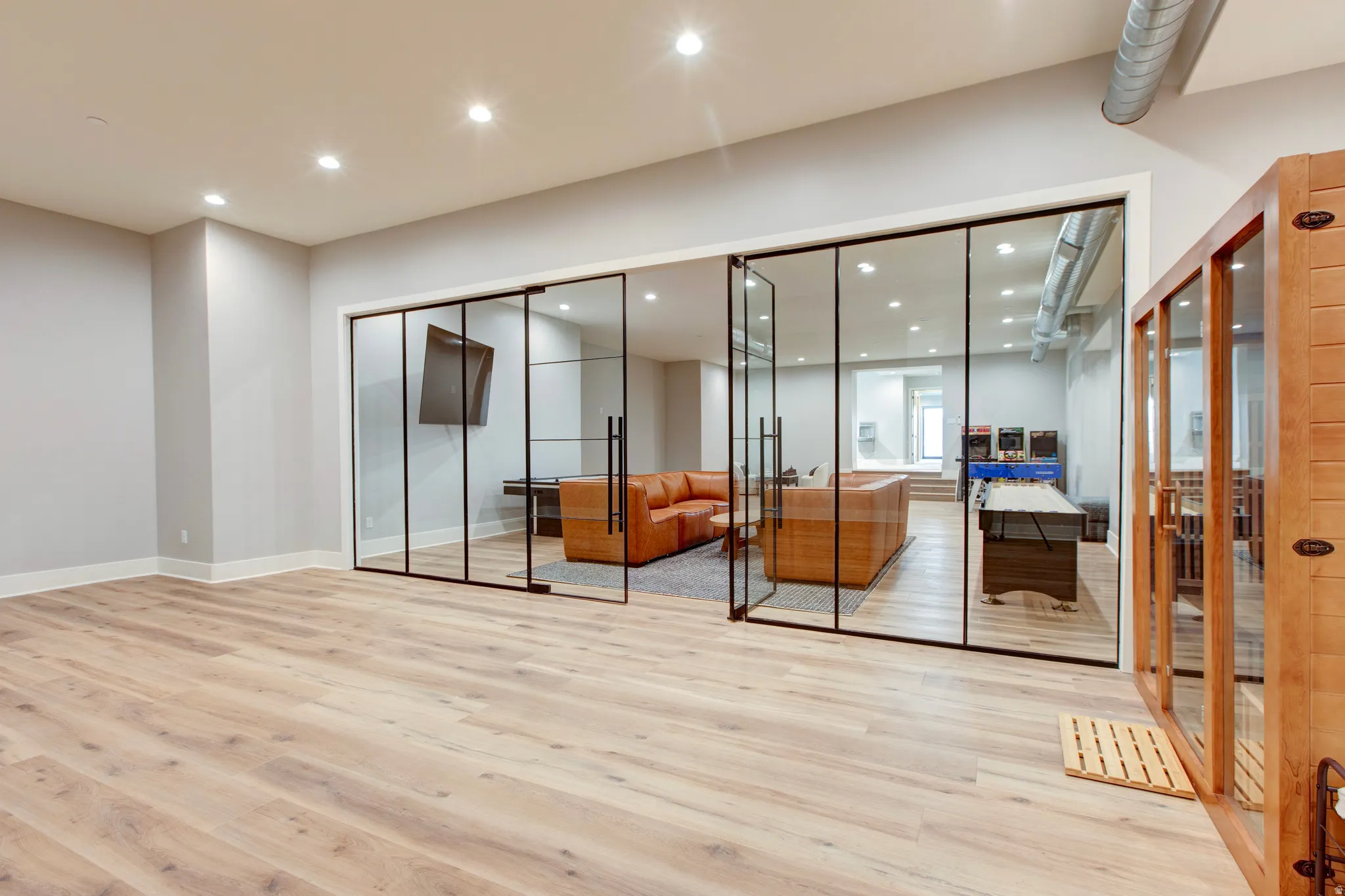 Open-concept space featuring light wood-finish flooring, recessed lighting, and a neutral color palette