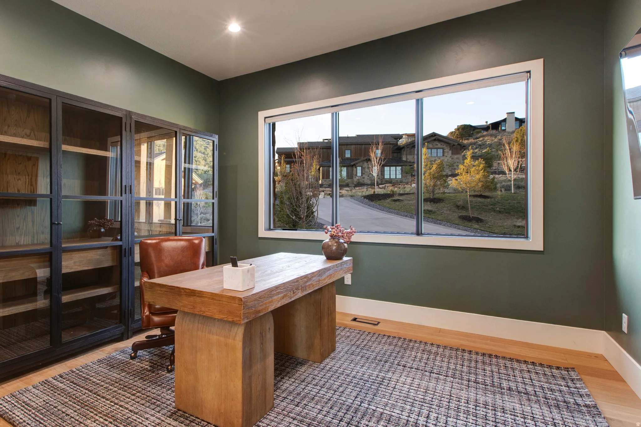Room featuring wood-finish flooring, a contemporary window, and built-in industrial-style cabinetry
