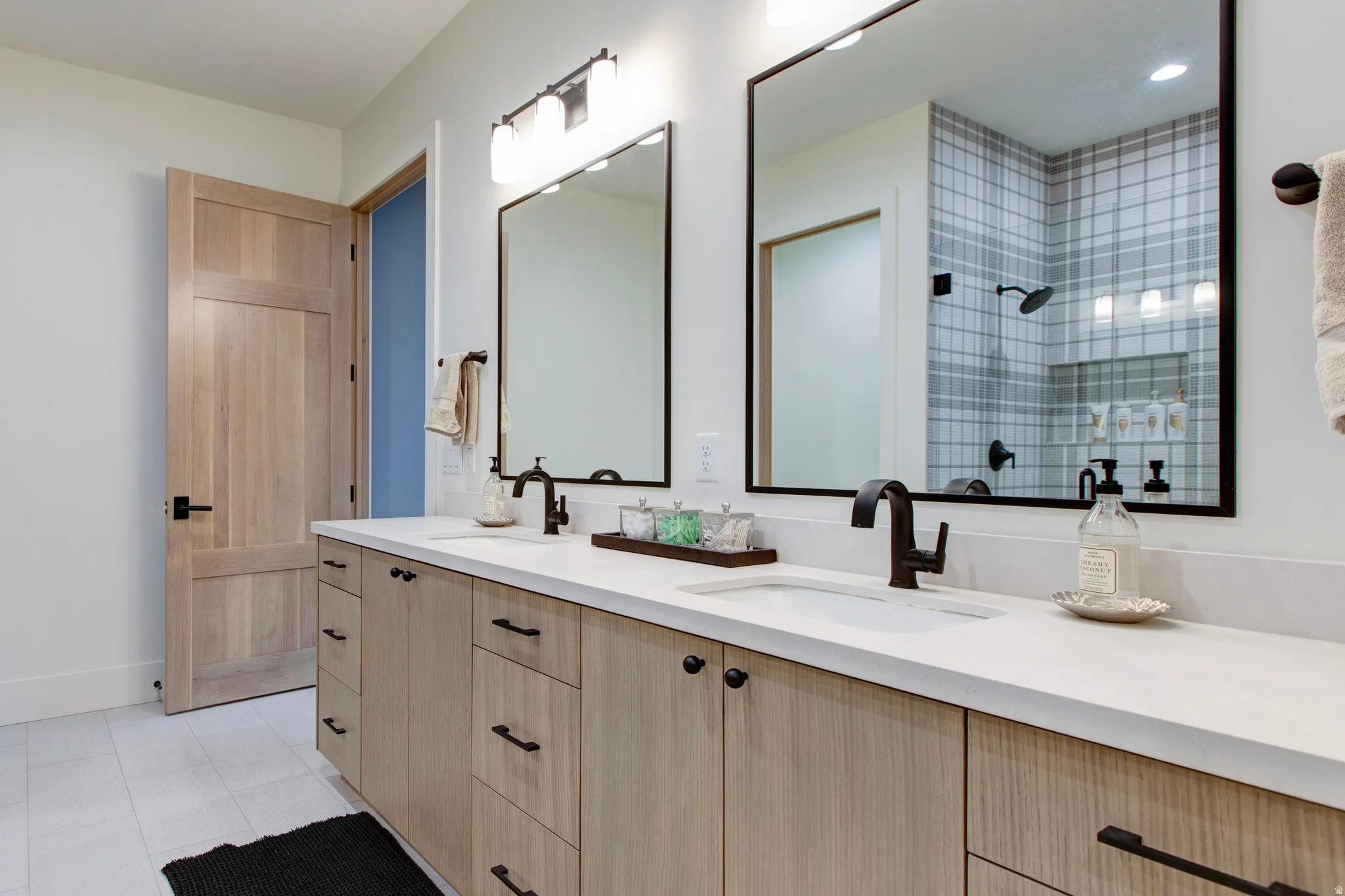 Dual vanity with white countertops and light wood-finish cabinetry