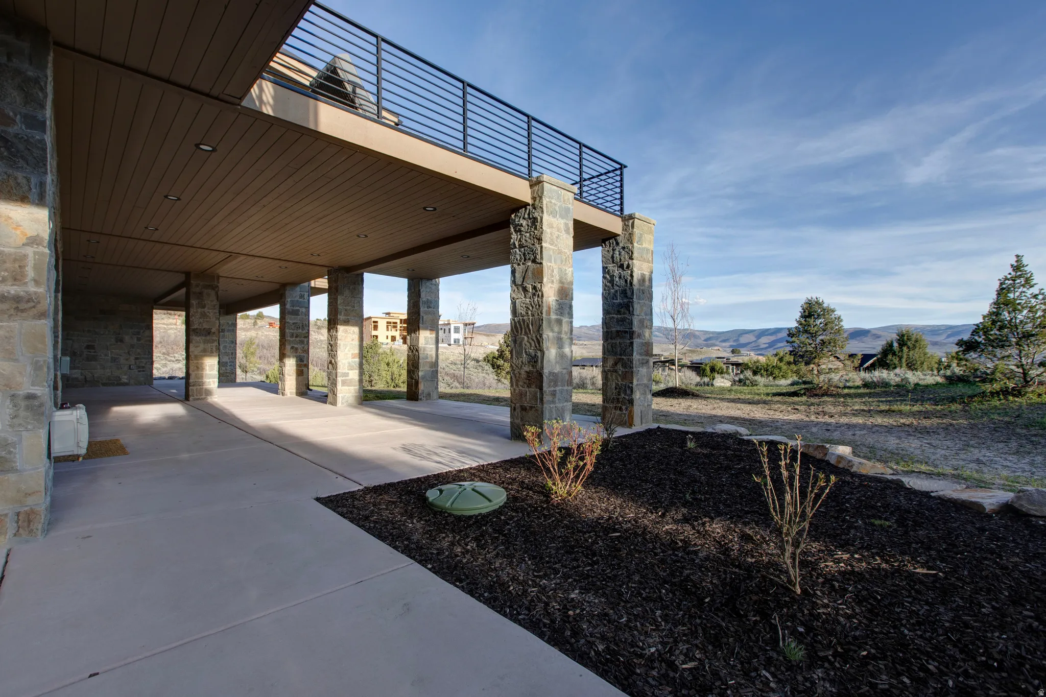 Covered patio featuring stone pillars and a planked ceiling with recessed lighting