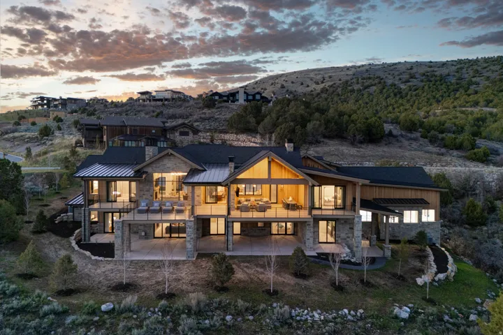 Contemporary multi-level residence featuring a stone and wood facade
