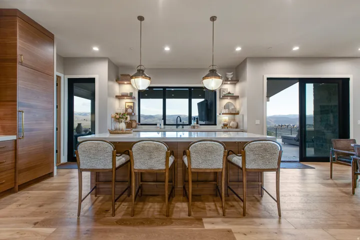 Spacious kitchen island with seating for four, set against wood-finish flooring