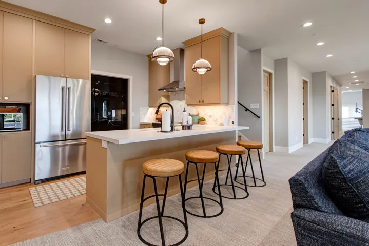 Kitchen featuring a white countertop island, stainless steel appliances, wood-finish flooring, and recessed lighting