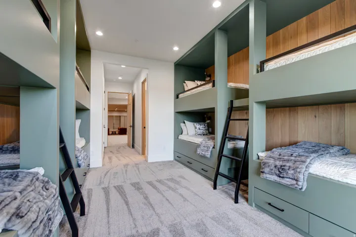 Built-in bunk beds featuring a sage green finish and wood-panel accents