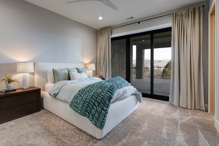 Carpeted room featuring a modern ceiling fan, recessed lighting, and a full-length sliding glass door opening to a private outdoor area