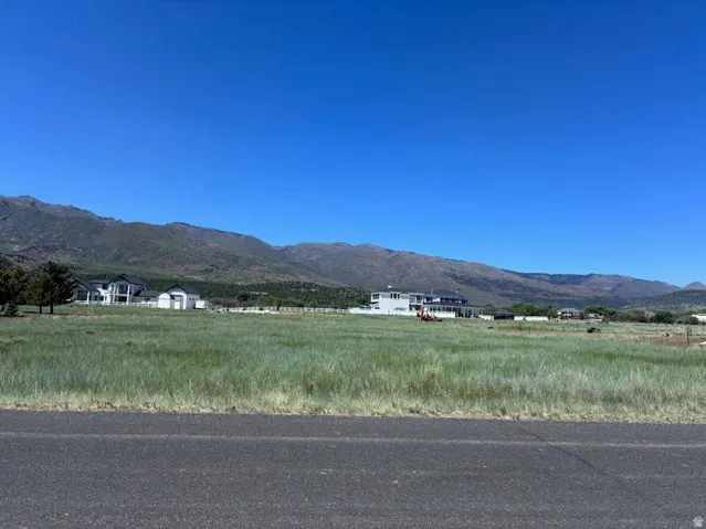 Expansive undeveloped land parcel featuring natural grass, a clear horizon, and distant mountain ranges