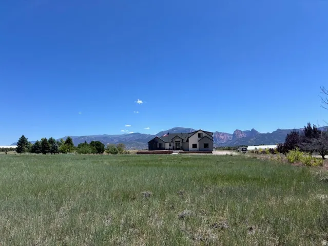 Spacious lot with a new construction residence featuring a light-toned exterior and dark roofing