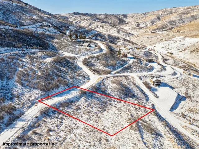 Snowy aerial view with a mountain view and property boundaries highlighted
