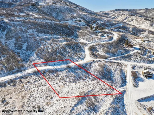 Snowy aerial view featuring property boundaries highlighted and a mountain view