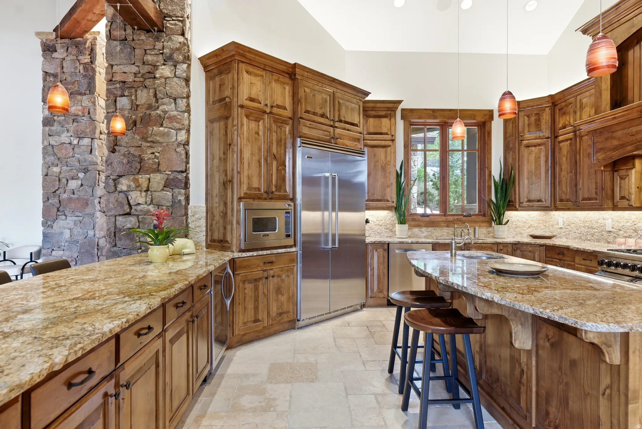 Spacious kitchen featuring extensive cabinetry with decorative molding, stainless steel appliances, and a large central island with bar seating
