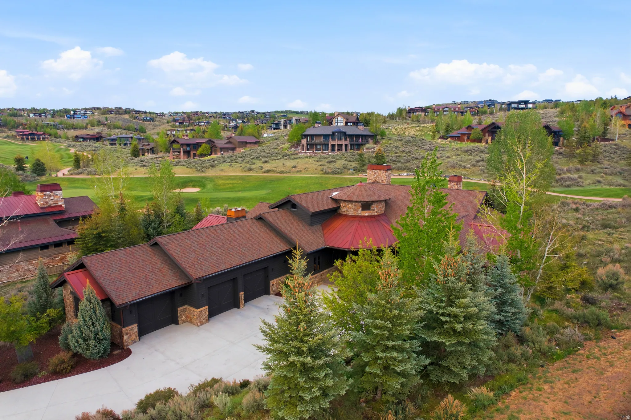 Multi-level residence featuring a prominent red roof and a three-car garage