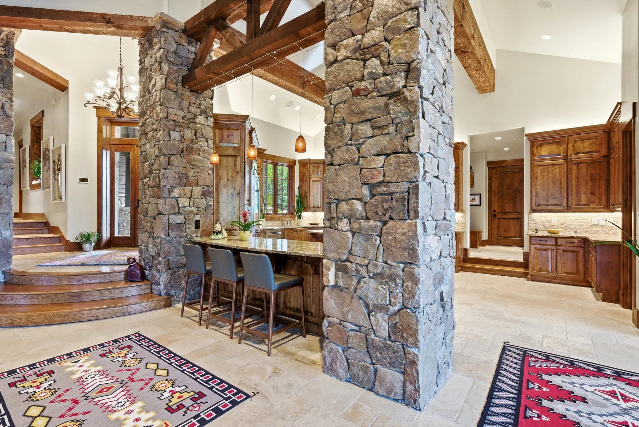 Stone-clad structural column framing a spacious interior with exposed wood beams