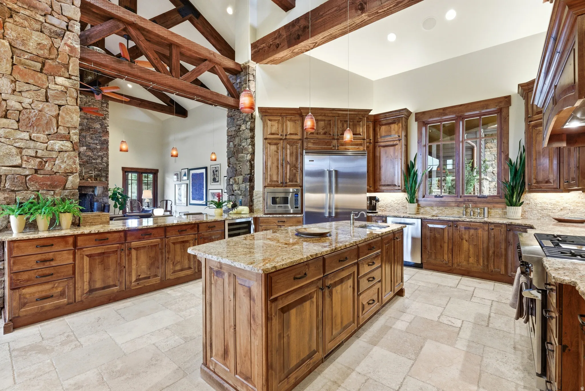 Gourmet kitchen featuring a large central island with granite countertops, rich wood cabinetry, stainless steel appliances, and tile flooring