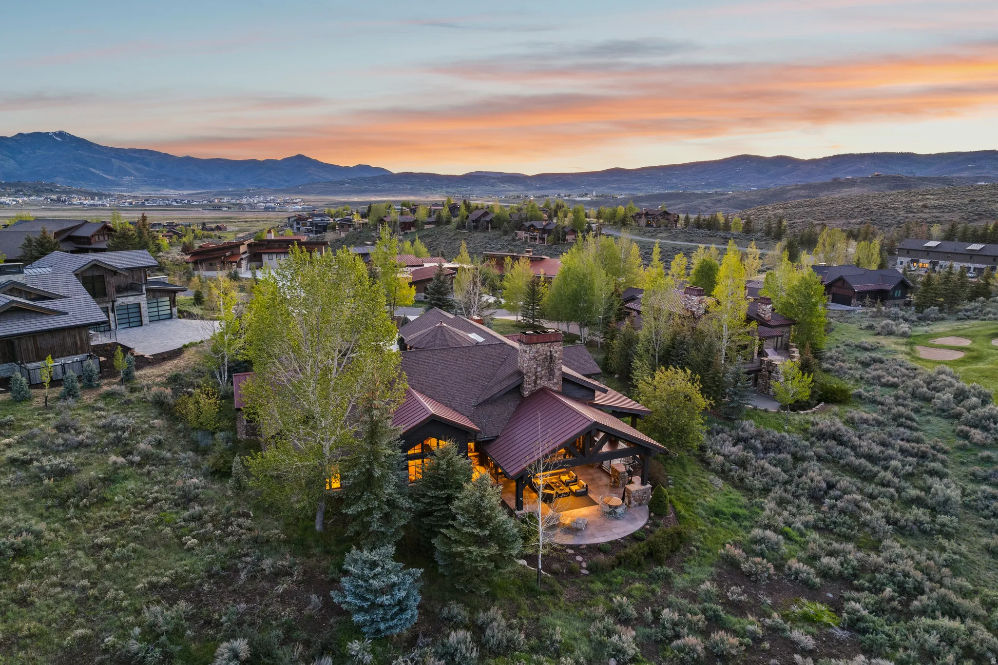 Mountain property featuring a multi-level design, stone chimney, and a covered outdoor patio