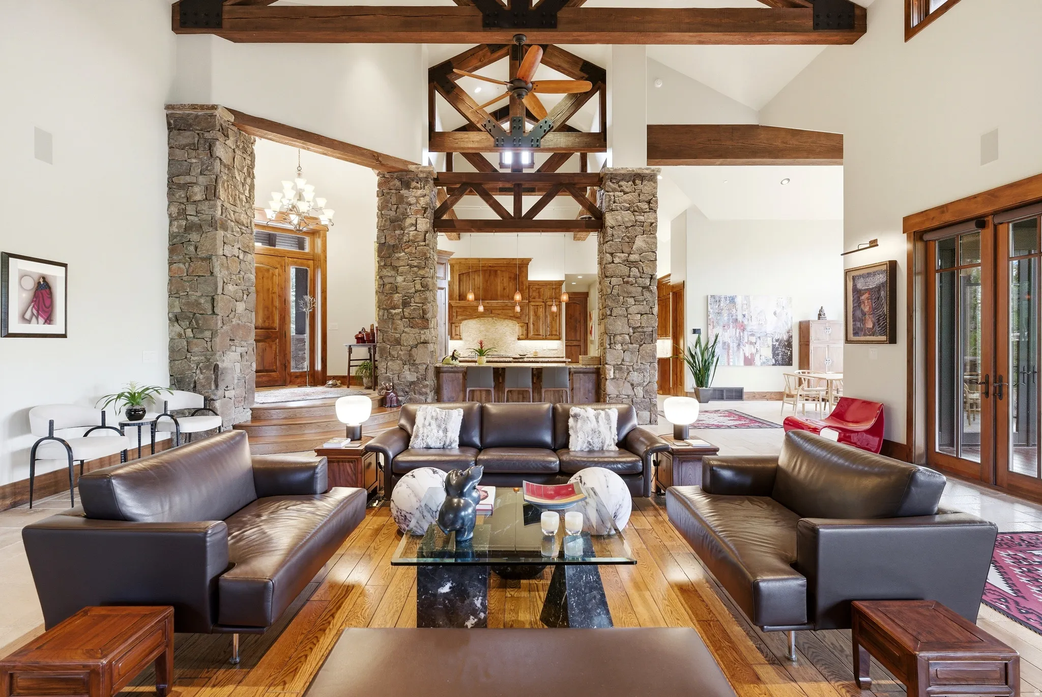 Great room featuring vaulted ceilings, exposed wood beams, and stone columns