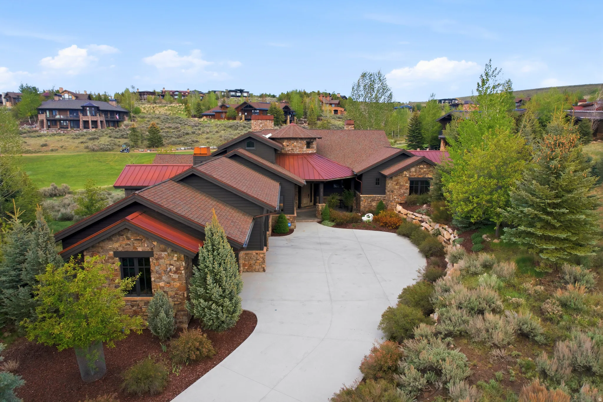Stone and siding exterior with red metal roof accents