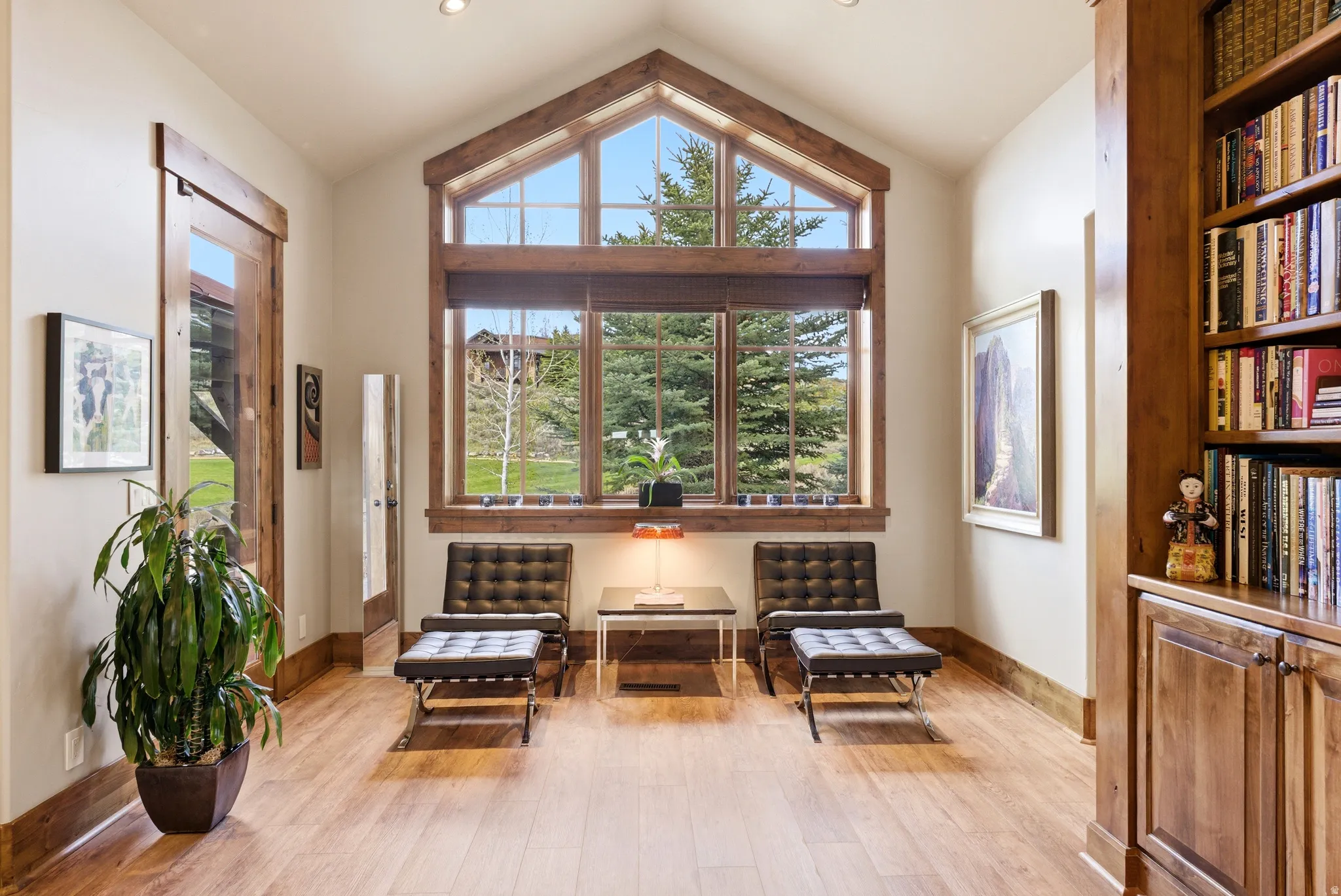 Vaulted ceilings with recessed lighting complement the prominent window wall featuring a gabled design
