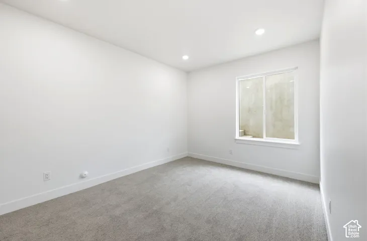 Carpeted room featuring recessed lighting, a white framed window with a deep sill, and white baseboards